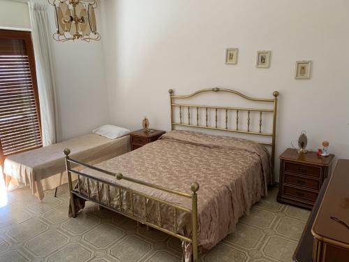 a bedroom with two beds and a chandelier at Appartamento Policastro Bussentino in Policastro Bussentino