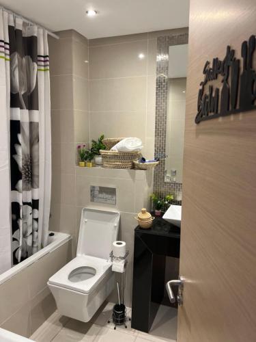 a bathroom with a white toilet and a sink at Super appartement familial avec piscine à Prestigia Marrakech in Marrakech