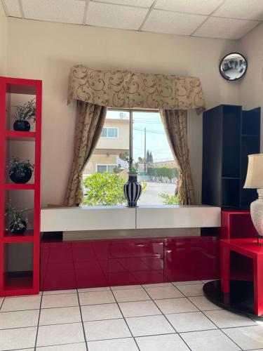 uma cozinha com armários vermelhos e uma janela em Grand Inn em Fullerton
