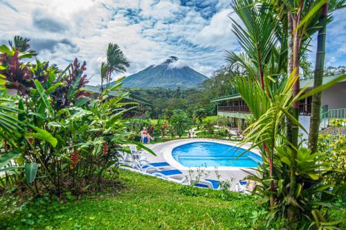 a resort with a pool and a mountain in the background at Hotel Lavas Tacotal in Fortuna