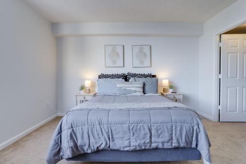 a white bedroom with a large bed and two lamps at Splendid 1 Bedroom Condo At Ballston With Gym in Arlington