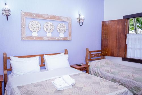 Ένα ή περισσότερα κρεβάτια σε δωμάτιο στο Casa de Violeta Pousada