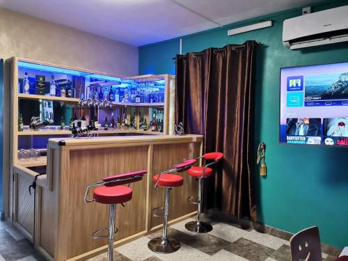 a bar with red stools in front of a counter at 3A'S COASTAL GUEST HOUSE in Riambel