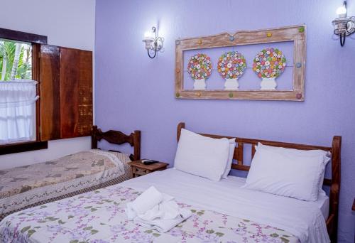 Ένα ή περισσότερα κρεβάτια σε δωμάτιο στο Casa de Violeta Pousada