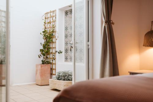 a bedroom with a mirror and a potted plant at Casa Morera - Best Villas Lanzarote in Teguise