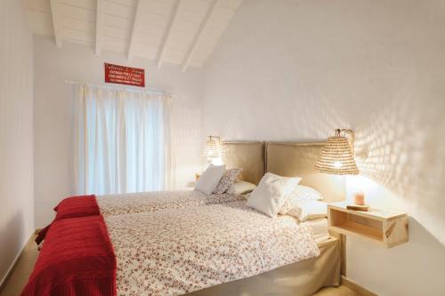 a bedroom with a bed with two lamps and a window at Casa Morera - Best Villas Lanzarote in Teguise