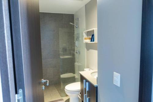 a bathroom with a shower and a toilet and a sink at Rooftop Jacuzzi and city view in San José