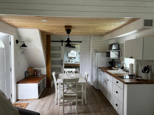 a kitchen with white cabinets and a table with chairs at Maria's Tiny Barn in Homestead