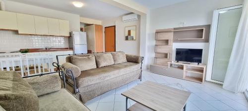 a living room with a couch and a kitchen at Bungalow White Apartments in Polykhrono