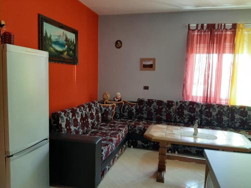 ein Wohnzimmer mit einem Sofa und einem Tisch in der Unterkunft Guesthouse Lula in Tepelenë