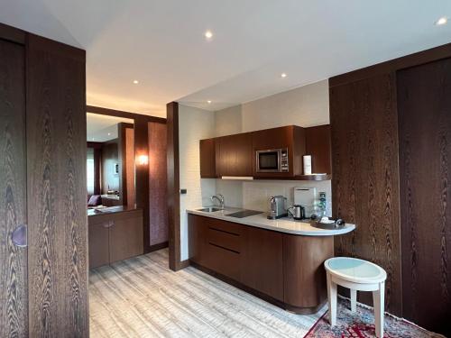 une cuisine avec des placards en bois, une table et un tabouret dans l'établissement Studio dans le quartier luxe, à Neuilly-sur-Seine