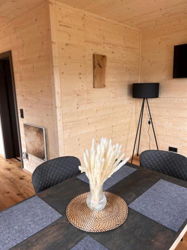 una mesa de comedor con sillas y un jarrón con flores blancas en Ferienresort Edersee GmbH, en Hemfurth-Edersee