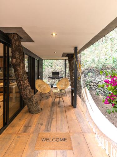 a house in the woods with a wrap around porch at Fungi Tepoz Cabins in Tlacotenco