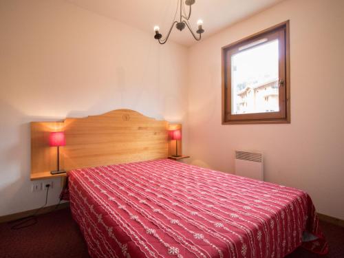 - une chambre avec un lit rouge et une fenêtre dans l'établissement Appartement cosy au pied des pistes - 6 pers, 40m², terrasse, parking, proche commerces et services - FR-1-508-13, à Lanslevillard