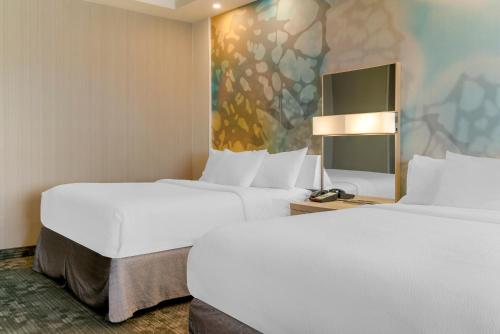 two beds in a hotel room with white sheets at Courtyard by Marriott Toledo North in Toledo