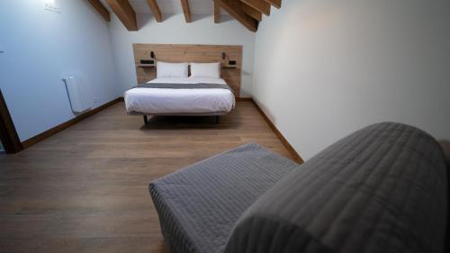 a bedroom with a bed and a couch in a room at Apartamentos Puerta de Occidente in Cornellana