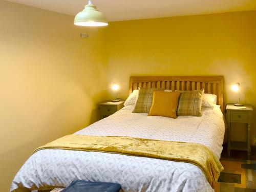 a bedroom with a large bed with yellow walls at Umber House in Dean Prior