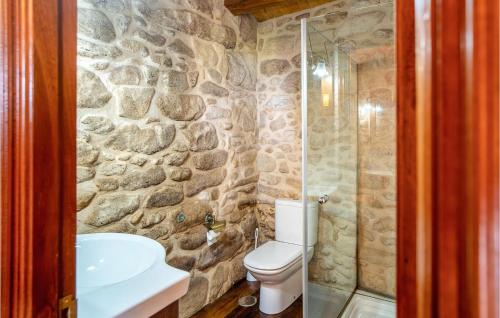 a stone bathroom with a toilet and a shower at Awesome Home In Muros With Wifi And 2 Bedrooms in Muros