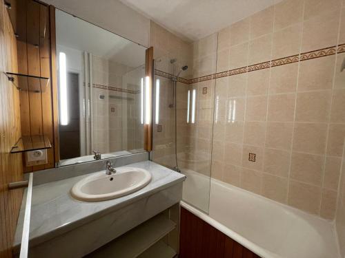 une salle de bain avec un lavabo, un miroir et une baignoire dans l'établissement Appartement cosy avec balcon, 2 pièces, 5 pers, proche pistes et commerces - FR-1-452-249, aux Menuires