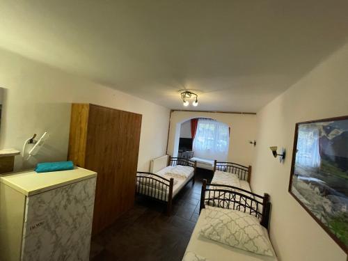 a room with two beds and a living room at Chata Korenný vrch Pezinská Baba in Pezinok