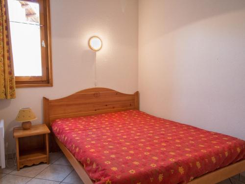 a small bedroom with a bed with a red blanket at Appartement Aussois, 3 pièces, 6 personnes - FR-1-508-152 in Aussois