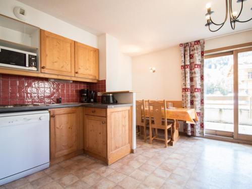 une cuisine avec des armoires en bois et une table à l'intérieur dans l'établissement Appartement cosy 5 pers. au pied des pistes à Val Cenis, terrasse, parking, proche commerces - FR-1-508-159, à Lanslevillard