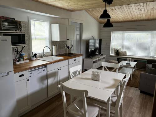 a kitchen with white cabinets and a table and chairs at Maria's Tiny Barn in Homestead