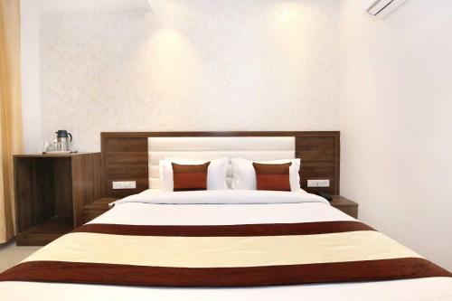 a bedroom with a large bed with red pillows at Hotel O Grand Star in Amritsar