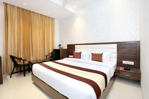 a hotel room with a large bed and a desk at Hotel O Grand Star in Amritsar