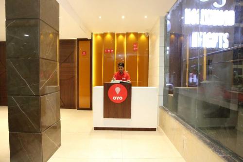 a man standing behind a podium in a lobby at Hotel O Grand Star in Amritsar