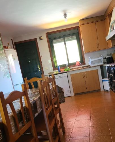 a kitchen with a table and chairs in it at Alojamiento Pena da Osa in Sober