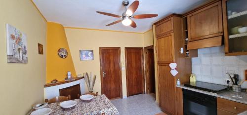 a kitchen with a table and a ceiling fan at Casa Lory in Pescina