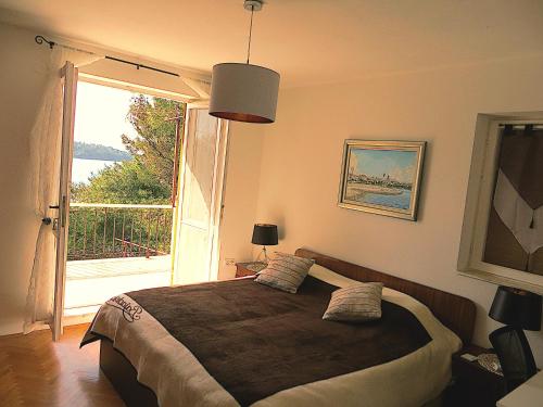 a bedroom with a large bed with a large window at VillaV, seafront 2-story 4* apartment with great outdoors in Prizba