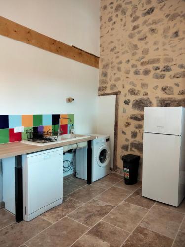 a kitchen with a refrigerator and a washing machine at La Grange de Sabatas in Chomérac