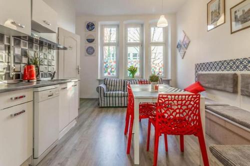 - une cuisine avec des chaises rouges et une table dans une chambre dans l'établissement Vibe Hostel Sopot, à Sopot