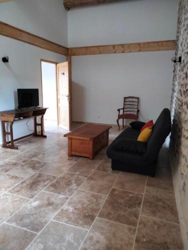 a living room with a couch and a table at La Grange de Sabatas in Chomérac
