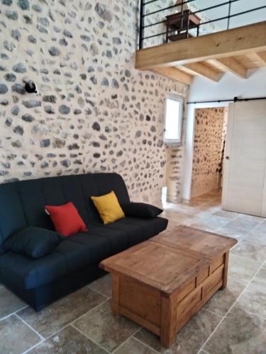 a living room with a couch and a wooden coffee table at La Grange de Sabatas in Chomérac
