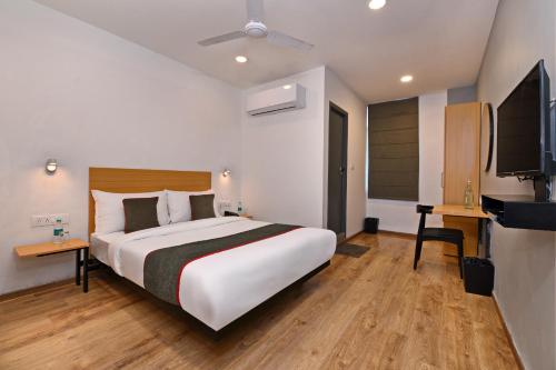 a bedroom with a large bed and a flat screen tv at Townhouse Function Inn Near Chaudhary Charan Singh International Airport in Charbagh