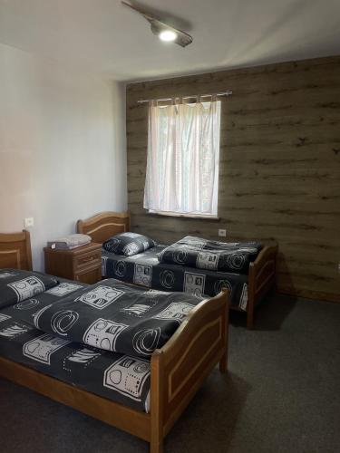 three beds in a room with wooden walls and a window at Armenian Camp, Sevan in Artanish