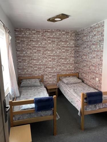 two beds in a room with a brick wall at Armenian Camp, Sevan in Artanish