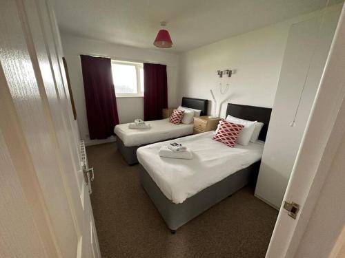 a hotel room with two beds and a window at St Anns Cottage 9 in Gunnislake