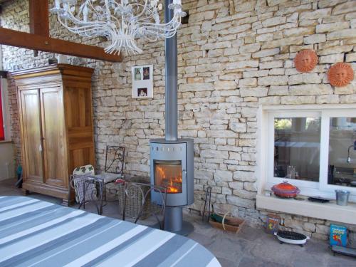 a fireplace in a room with a stone wall at Les Petunias in Hugier