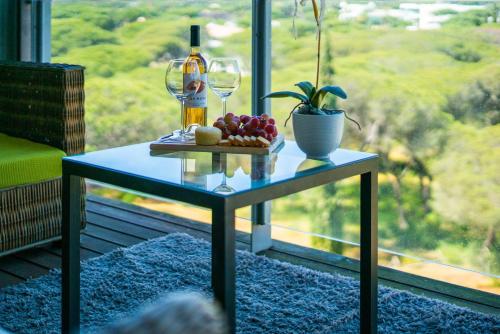 a table with a bottle of wine and a plate of fruit at 1 Bed With Balcony Pool and Tennis in Quarteira