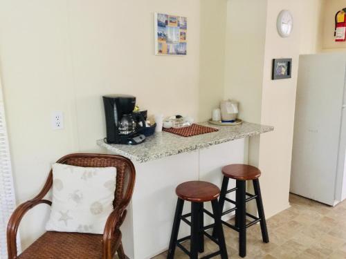 a kitchen with a counter and two stools at Sesuit Harbor House in East Dennis
