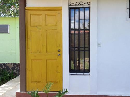 Hostal Puertas De Apaneca في Apaneca: باب أصفر على جانب المنزل