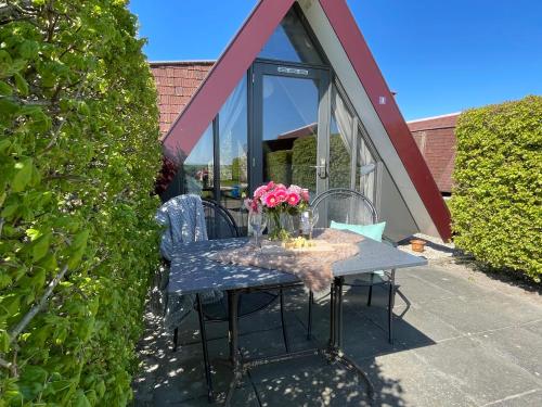 een tafel met een vaas met bloemen erop bij Hotelhuisjes Andijk in Andijk