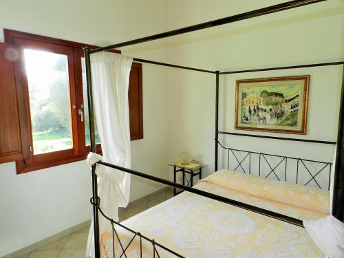 - une chambre avec un lit à baldaquin et une fenêtre dans l'établissement Chicchiritanos, à Monti