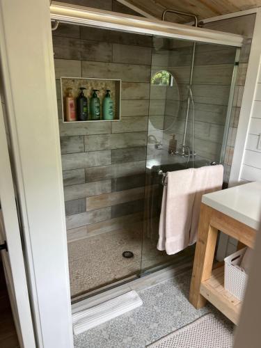 a shower with a glass door in a bathroom at Maria's Tiny Barn in Homestead