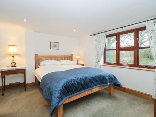 Schlafzimmer mit einem Bett und einem Fenster in der Unterkunft Oak Barn in Cullompton