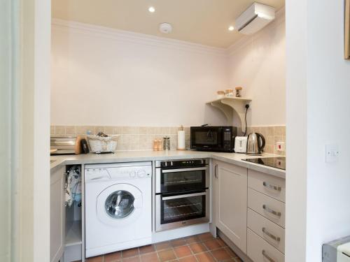 una cocina con lavadora y secadora. en Orchard Cottage At Braidwood Castle - Uk10671, en Braidwood
